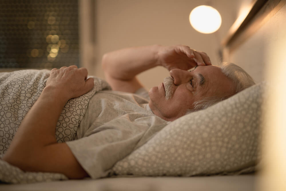 worried senior man thinking something while resting bed night